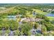 Aerial view of community showcasing clubhouse, pool, tennis courts, lush green landscaping, and golf course at 9734 Carnoustie Pl, Bradenton, FL 34211