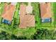 Aerial view of a home with tile roof surrounded by lush greenery and well-manicured lawns, offering a serene outdoor space at 9734 Carnoustie Pl, Bradenton, FL 34211