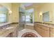 Bathroom featuring a tub, a glass-enclosed shower, and double vanity sinks at 9734 Carnoustie Pl, Bradenton, FL 34211