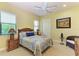Light bedroom with a bed, bedside tables, and a ceiling fan at 9734 Carnoustie Pl, Bradenton, FL 34211