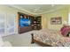 Comfortable bedroom featuring a large patterned bedspread, tray ceiling, and built-in media center at 9734 Carnoustie Pl, Bradenton, FL 34211