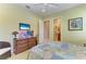Light and airy bedroom with dresser, stylish decor, and a view into the attached bathroom at 9734 Carnoustie Pl, Bradenton, FL 34211