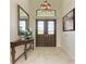 Inviting foyer with tiled flooring, elegant lighting, and a decorative console table at 9734 Carnoustie Pl, Bradenton, FL 34211