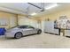 Spacious garage with epoxy floors, storage cabinets, and a new vehicle at 9734 Carnoustie Pl, Bradenton, FL 34211
