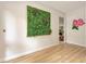Modern hallway features an accent wall with a decorative vertical garden, modern lighting, and wood flooring at 9734 Carnoustie Pl, Bradenton, FL 34211