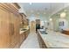 Spacious kitchen with wood cabinetry, tile backsplash, and large granite island with stainless steel sink at 9734 Carnoustie Pl, Bradenton, FL 34211