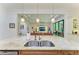 Large granite kitchen island with stainless steel sinks, and a view of the open living room and dining area at 9734 Carnoustie Pl, Bradenton, FL 34211