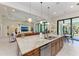 Open kitchen with a view of the living room, with large granite island and stainless steel appliances at 9734 Carnoustie Pl, Bradenton, FL 34211