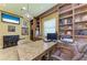 Comfortable home office with custom shelving, a granite desk, and a reading chair at 9734 Carnoustie Pl, Bradenton, FL 34211