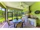 Screened lanai with a fully equipped outdoor kitchen, including a built-in grill and entertainment area at 9734 Carnoustie Pl, Bradenton, FL 34211