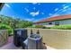 Back patio features an AC system, enclosed by a stucco wall with a view of the roof at 9734 Carnoustie Pl, Bradenton, FL 34211