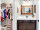 Bathroom featuring a vanity with storage and mirror and a door leading to a closet with clothing storage at 13116 Bliss Loop, Bradenton, FL 34211
