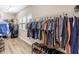 Walk-in closet featuring wood floor and ample clothing storage with shelving and hanging rods at 13116 Bliss Loop, Bradenton, FL 34211