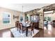 Elegant dining room with stone accent wall, modern chandelier, and dark wood flooring at 13116 Bliss Loop, Bradenton, FL 34211