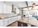 Kitchen with island and seating, granite counters and stone accent wall at 13116 Bliss Loop, Bradenton, FL 34211
