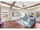 Bright living room featuring wood floors, beamed ceilings, and custom entertainment center at 13116 Bliss Loop, Bradenton, FL 34211