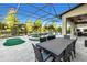 Outdoor dining area and putting green complement the screened-in pool and lake views at 13116 Bliss Loop, Bradenton, FL 34211