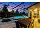 Outdoor dining and lounge areas flank a screened-in pool with water feature and lake views at 13116 Bliss Loop, Bradenton, FL 34211