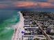 Breathtaking aerial view of a beachfront property with stunning sunset skies and turquoise ocean waters at 101 66Th St # 1, Holmes Beach, FL 34217