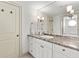 Well-lit bathroom with a granite countertop, white cabinetry, and a decorative mirror at 101 66Th St # 1, Holmes Beach, FL 34217