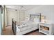 Bright bedroom features a metal bed, light wood floors, and an attached bathroom at 101 66Th St # 1, Holmes Beach, FL 34217