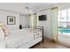 Cozy bedroom with a black metal bed frame, TV, and windows overlooking the water at 101 66Th St # 1, Holmes Beach, FL 34217