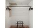 Simple closet space with a hanging bar, wooden floors, and a luggage rack below at 101 66Th St # 1, Holmes Beach, FL 34217