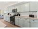 Bright kitchen with sleek appliances, ample counter space, and partial view of living area at 101 66Th St # 1, Holmes Beach, FL 34217