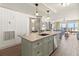 Open-concept kitchen with a kitchen island and stainless steel appliances overlooking a living area with beach views at 101 66Th St # 1, Holmes Beach, FL 34217
