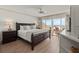 Main bedroom features a dark wood bed frame, soft lighting, and views of the beach at 101 66Th St # 1, Holmes Beach, FL 34217