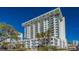 Modern condominium building with white facade and multiple balconies under a clear blue sky at 101 S Gulfstream Ave # 5J, Sarasota, FL 34236