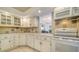 Bright kitchen features white cabinets and appliances plus backsplash tile, seamlessly open to the adjacent living space at 101 S Gulfstream Ave # 5J, Sarasota, FL 34236