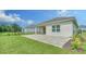 A paved outdoor patio and a grassy lawn, perfect for outdoor entertaining and relaxation at 10105 Canaveral Cir, Sarasota, FL 34241