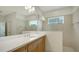 Bathroom features a vanity with wood cabinets, ample countertop space, and a large mirror, combining style and functionality at 10105 Canaveral Cir, Sarasota, FL 34241