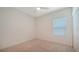 Unfurnished bedroom featuring neutral walls and carpet, a ceiling fan, closet with bifold doors and a window at 10105 Canaveral Cir, Sarasota, FL 34241