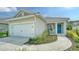 Beautiful home featuring a two-car garage, elegant landscaping, and a charming front porch with rocking chairs at 10105 Canaveral Cir, Sarasota, FL 34241