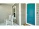 Inviting front porch with two rocking chairs and a blue door, offering a cozy welcome to the home at 10105 Canaveral Cir, Sarasota, FL 34241