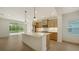 Modern kitchen with stainless steel appliances and large island with pendant lighting flowing into the outdoor patio at 10105 Canaveral Cir, Sarasota, FL 34241