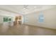 Bright living room with wood floors features a ceiling fan and large windows that offers an open concept layout at 10105 Canaveral Cir, Sarasota, FL 34241