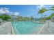 Community pool with lounge chairs, palm trees, and clear blue water at 10105 Canaveral Cir, Sarasota, FL 34241