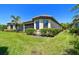 Beautiful backyard featuring lush green grass, tropical landscaping, and a screened-in lanai at 10205 Saint Francis Ter, Palmetto, FL 34221