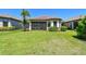 Lush backyard with manicured lawn, a screened-in patio, and vibrant landscaping, ideal for outdoor living at 10205 Saint Francis Ter, Palmetto, FL 34221