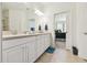 Well-lit bathroom with a double vanity and tiled floors leads into a carpeted bedroom at 10205 Saint Francis Ter, Palmetto, FL 34221