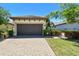 Home exterior features a two-car garage, manicured landscaping and a brick-paved driveway in a well-maintained community at 10205 Saint Francis Ter, Palmetto, FL 34221
