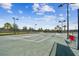 Well-maintained community tennis court with lighting, surrounded by mature trees and landscaping at 10205 Saint Francis Ter, Palmetto, FL 34221