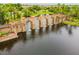 Picturesque water feature with stone arches and lush landscaping in the Artisan Lakes community at 10205 Saint Francis Ter, Palmetto, FL 34221