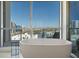 A soaking tub sits beneath a large window with views of the marina and the city at 111 Golden Gate Pt # 802Ph, Sarasota, FL 34236
