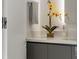 Elegant bathroom with quartz countertop, decorative flower, and modern gray cabinets at 111 Golden Gate Pt # 802Ph, Sarasota, FL 34236