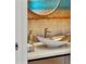 Stylish powder room featuring a gold vessel sink, designer faucet, and unique wall covering at 111 Golden Gate Pt # 802Ph, Sarasota, FL 34236