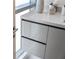 Close-up on the bathroom vanity, showing the modern sink, sleek drawers, and neutral countertop at 111 Golden Gate Pt # 802Ph, Sarasota, FL 34236